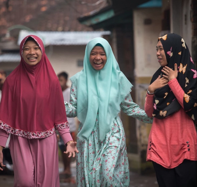 three girls in headdresses looking happy