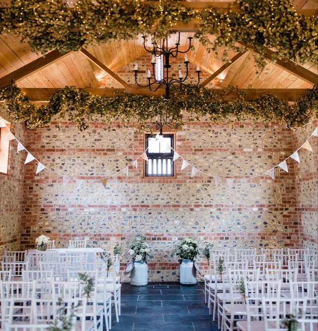 Interior of one of the barns at The Gathering Barn set up for a ceremony