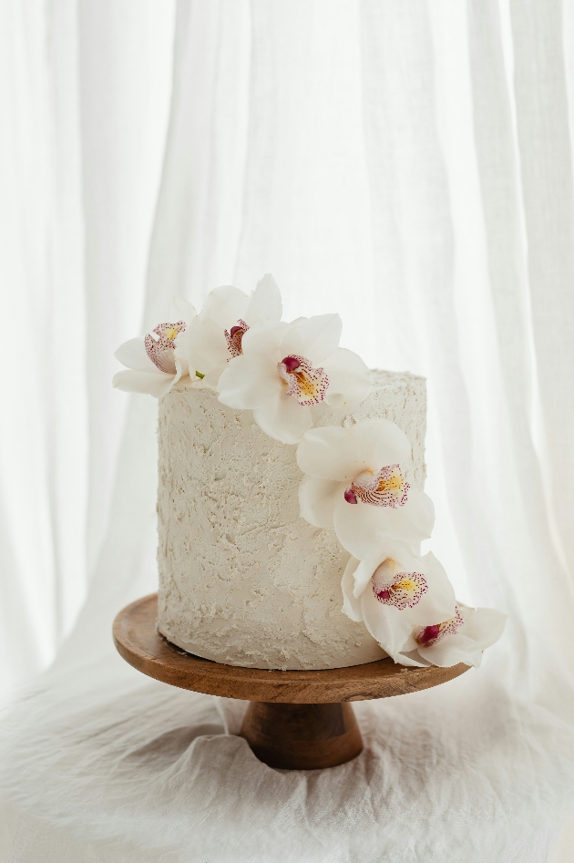 single tier wedding cake decorated with orchids