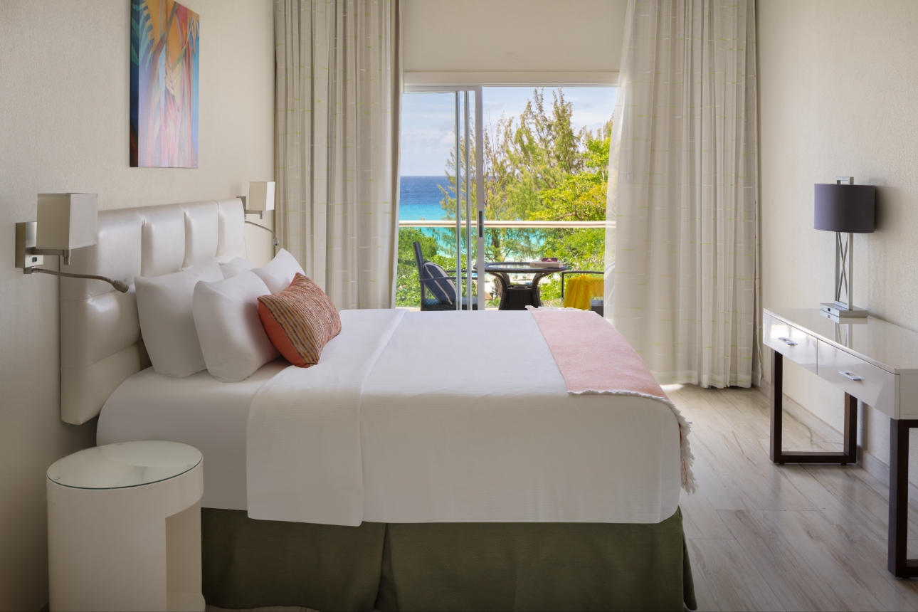 bedroom suite, white in tone, dresser, balcony with sea views 